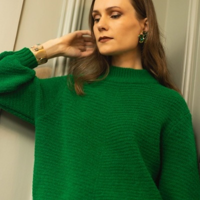 Blusão verde de malha com gola alta e mangas compridas usado por mulher