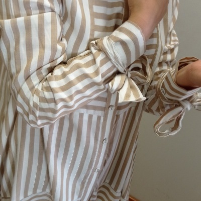 Camisa comprida riscada branca e bege com laçada nos punhos