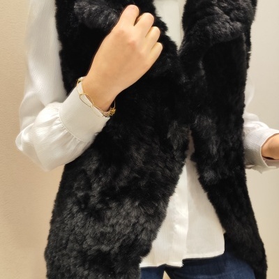 Colete de pêlo preto e camisa branca com calças de ganga e pulseira dourada