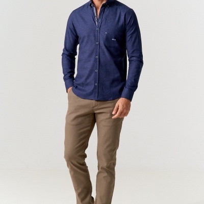 Homem com camisa azul escura, calças castanhas e sapatos desportivos