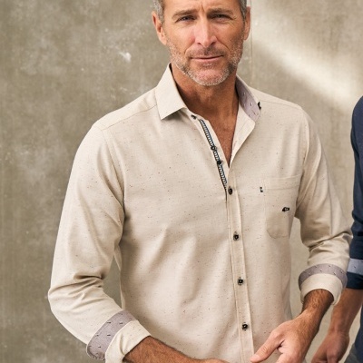 Camisa social bege clara com detalhes cinza e botões pretos, modelo masculino a usar em fundo cinza.