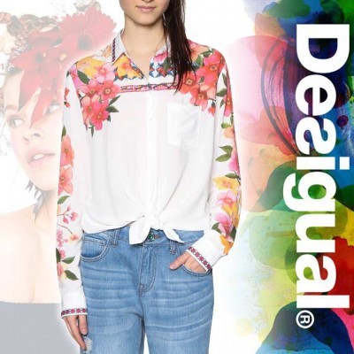Blusa branca com padrão floral colorido nas mangas e gola e jeans azul claro, fundo colorido com texto Desigual