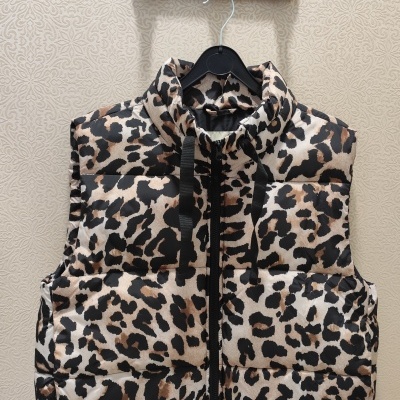 Colete acolchoado padrão animal print pendurado num cabide preto