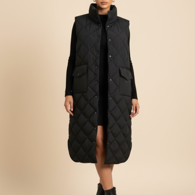 Mulher com colete acolchoado preto longo, vestido preto e botas pretas