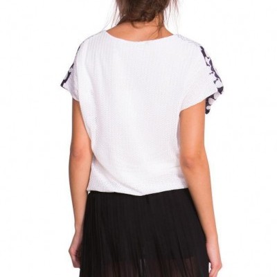 Mulher vista de costas com t-shirt branca e saia preta plissada