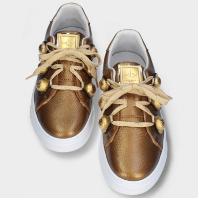 Sapatilhas castanhas com sola branca e ornamentos dourados.