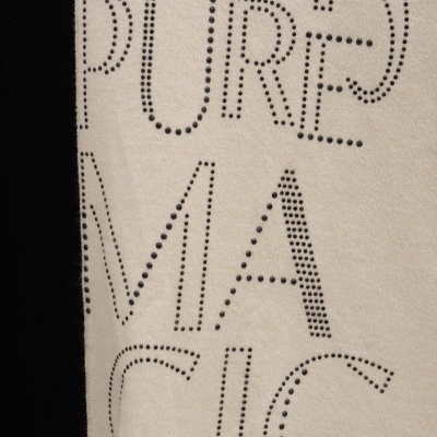 Tecido de malha com letras pontilhadas a preto em fundo bege e lateral preta com linha rosa