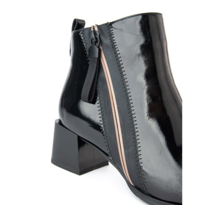 Botim digital em verniz preto com salto quadrado e detalhe bege