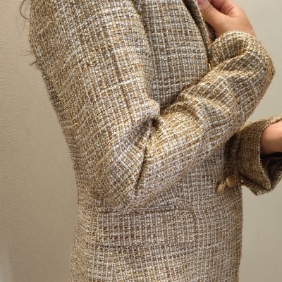 Blazer tweed dourado e branco com botões dourados, usado com jeans azuis