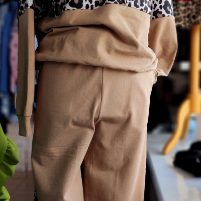 Fato de roupa bege com padrão animal print e capuz num manequim