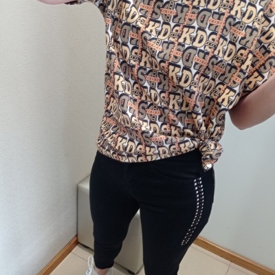 Pessoa com t-shirt estampada e calças pretas justas com ténis animal print