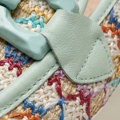 Pormenor de mala com fecho verde água e tecido bordado colorido