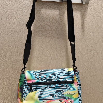 Mala de ombro colorida com padrão abstrato pendurada em gancho