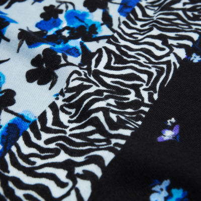 Tecido com padrão floral azul e preto e estampado zebrado em preto e branco