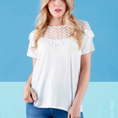 T-shirt feminina branca com renda e folho, calças azuis, fundo azul