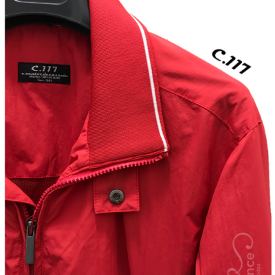 Casaco vermelho com etiqueta preta, gola canelada e texto made in Portugal