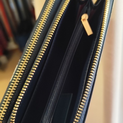 Carteira azul escuro com fechos dourados e interior compartimentado