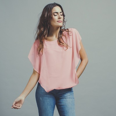 Mulher vestindo blusa rosa e calças de ganga azul