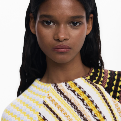 Mulher com suéter de malha colorido perto do rosto