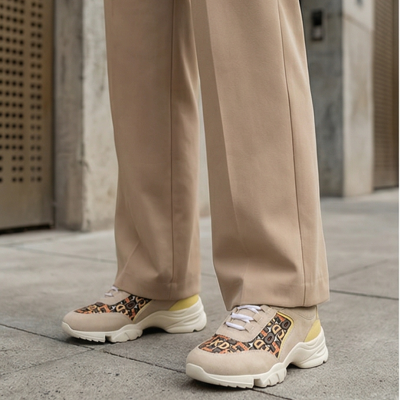 Sapatilhas bege com padrões pretos e laranja e sola branca