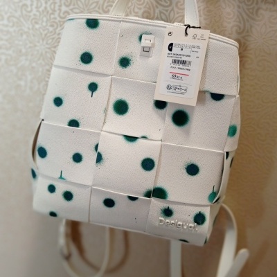 Mochila branca com pontos verdes e padrão quadrado