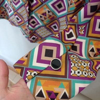 Manga de camisa colorida com padrão geométrico e botão preto