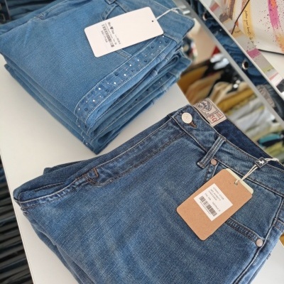 Calças de ganga azuis dobradas com etiquetas de preço em loja