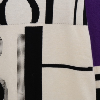 Tecido creme com padrão geométrico em preto e roxo e letras