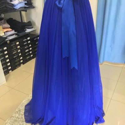 Vestido azul comprido com parte superior de lantejoulas e saia plissada com cinto de cetim em loja