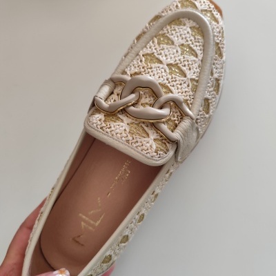 Sapato mocassim bege com padrão trançado e decoração metálica creme.