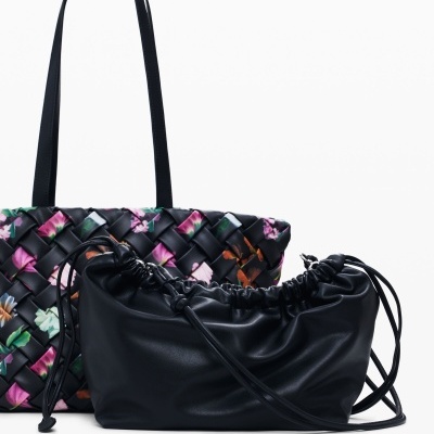 Duas malas femininas, uma preta lisa e outra preta trançada com flores coloridas