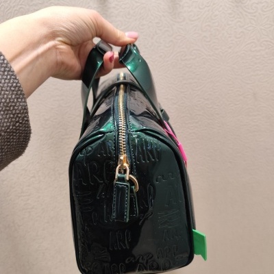 Mala verde escuro em verniz com padrão em relevo e alças verdes