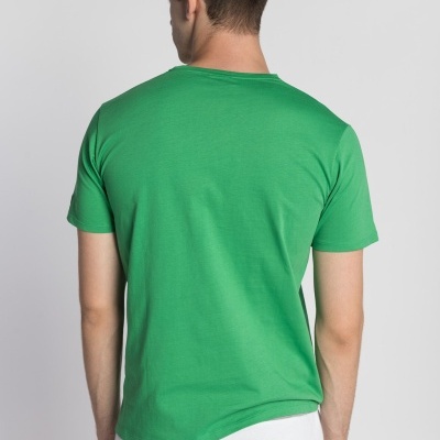 Homem de costas a usar t-shirt verde e calças brancas