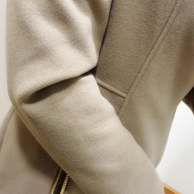 Manga de casaco bege com fecho dourado e costura diagonal