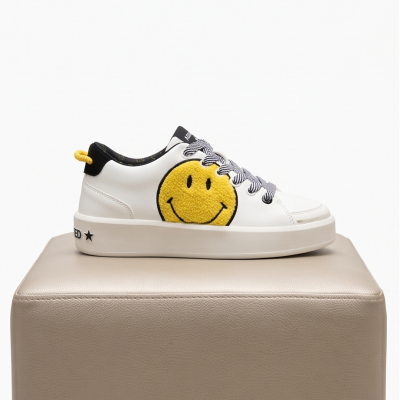 Ténis branco com rosto amarelo sorridente em textura de pelúcia