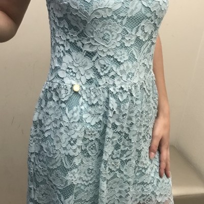 Vestido feminino azul claro de renda com padrão floral e detalhe de botão na cintura