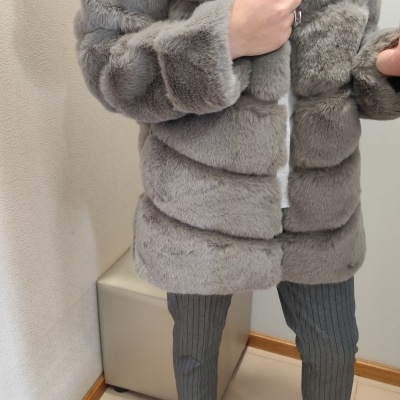 Casaco de pelo sintético cinza claro com calças risca de giz e botins pretos