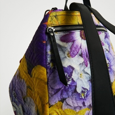 Mochila floral roxa, amarela e branca com alças pretas e fecho prateado