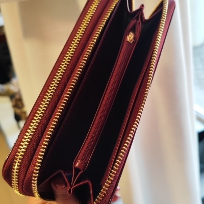 Carteira bordô com fechos dourados e vários compartimentos internos