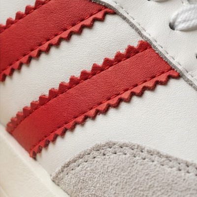 Sapatilha branca com riscas vermelhas e detalhe cinza em camurça