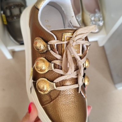 Ténis dourados em pele com botões dourados e sola branca