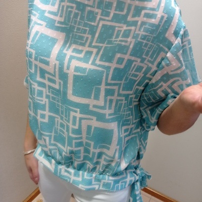 Blusa azul e branca com padrão geométrico e laço lateral