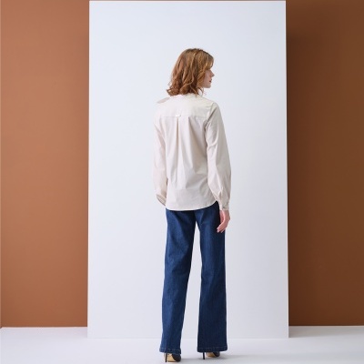 Pessoa de costas veste camisa branca e calças de ganga azuis