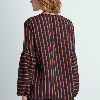 Blusa de riscas verticais em várias cores com mangas longas volumosas vista de costas