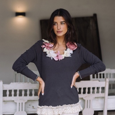 Camisola cinzenta com flores na gola e renda na barra usada por mulher