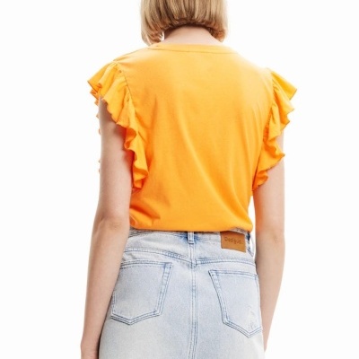 Vista traseira de mulher com camisola laranja de folhos e saia jeans azul clara desfiada.