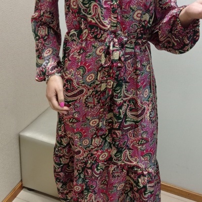 Vestido comprido floral e sandálias amarelas em interior