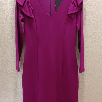 Vestido roxo com folhos nas ombreiras pendurado num cabide preto