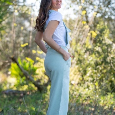 Mulher usando calça azul claro e t-shirt branca numa área verde