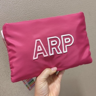 Mala rosa com letras bordadas ARP em branco